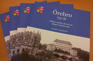 Fyra böcker på ett bord. Boktiteln är "Örebro 750 år".