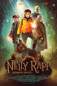 Nelly Rapp i orange jacka omgiven av fler karaktärer i filmen med en ficklampa riktad mot kameran med mörk och mystisk bakgrund.