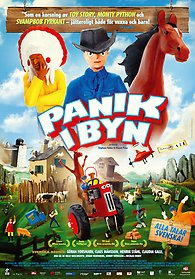 Plastfigurer av en ursprungsamerikan, cowboy och häst över texten "Panik i byn", under texten en röd traktor och andra figurer i en modell av en liten by med grönt gräs och berg i bakgrunden.
